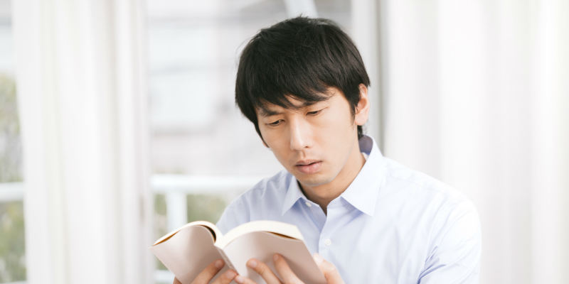 本を読んで勉強する男性